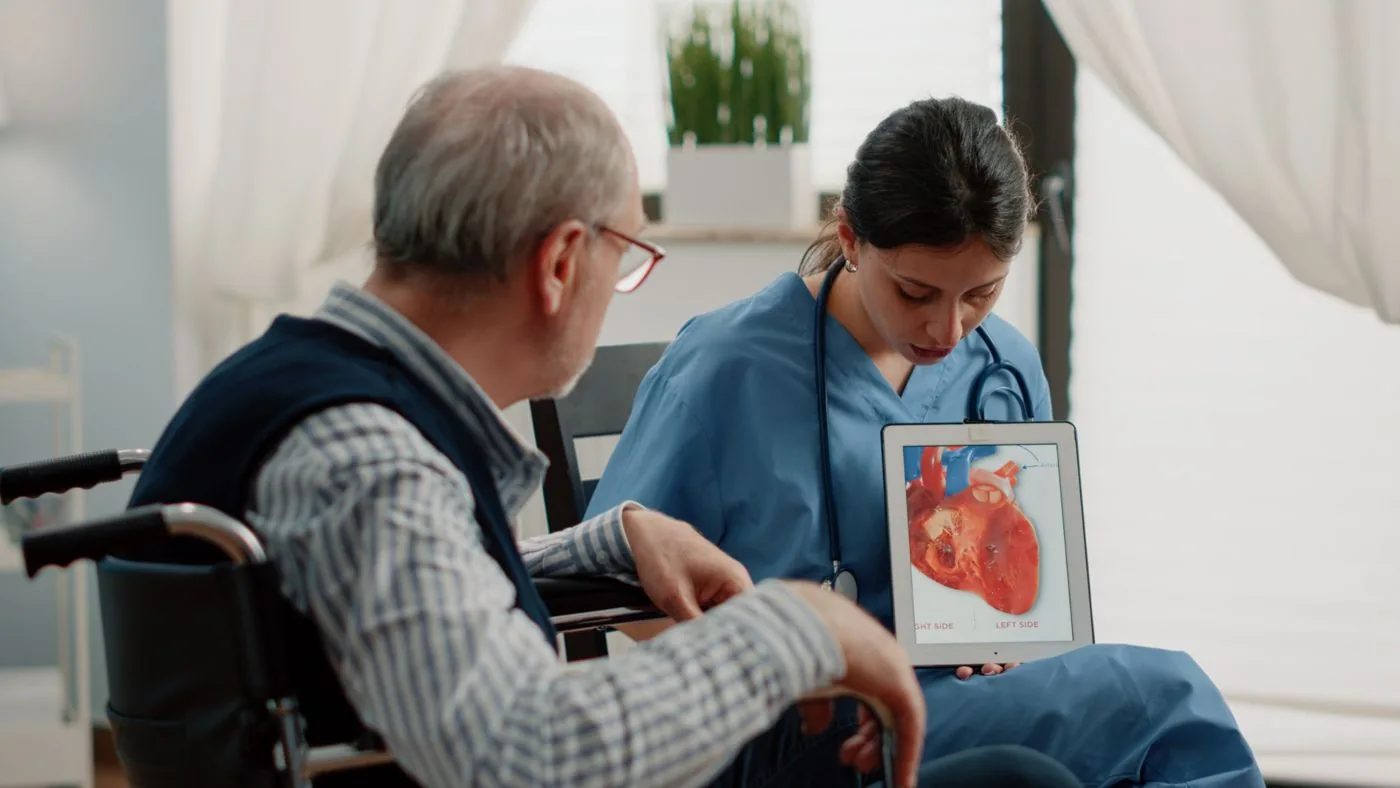 Nurse explaining a heart diagram to an older patient